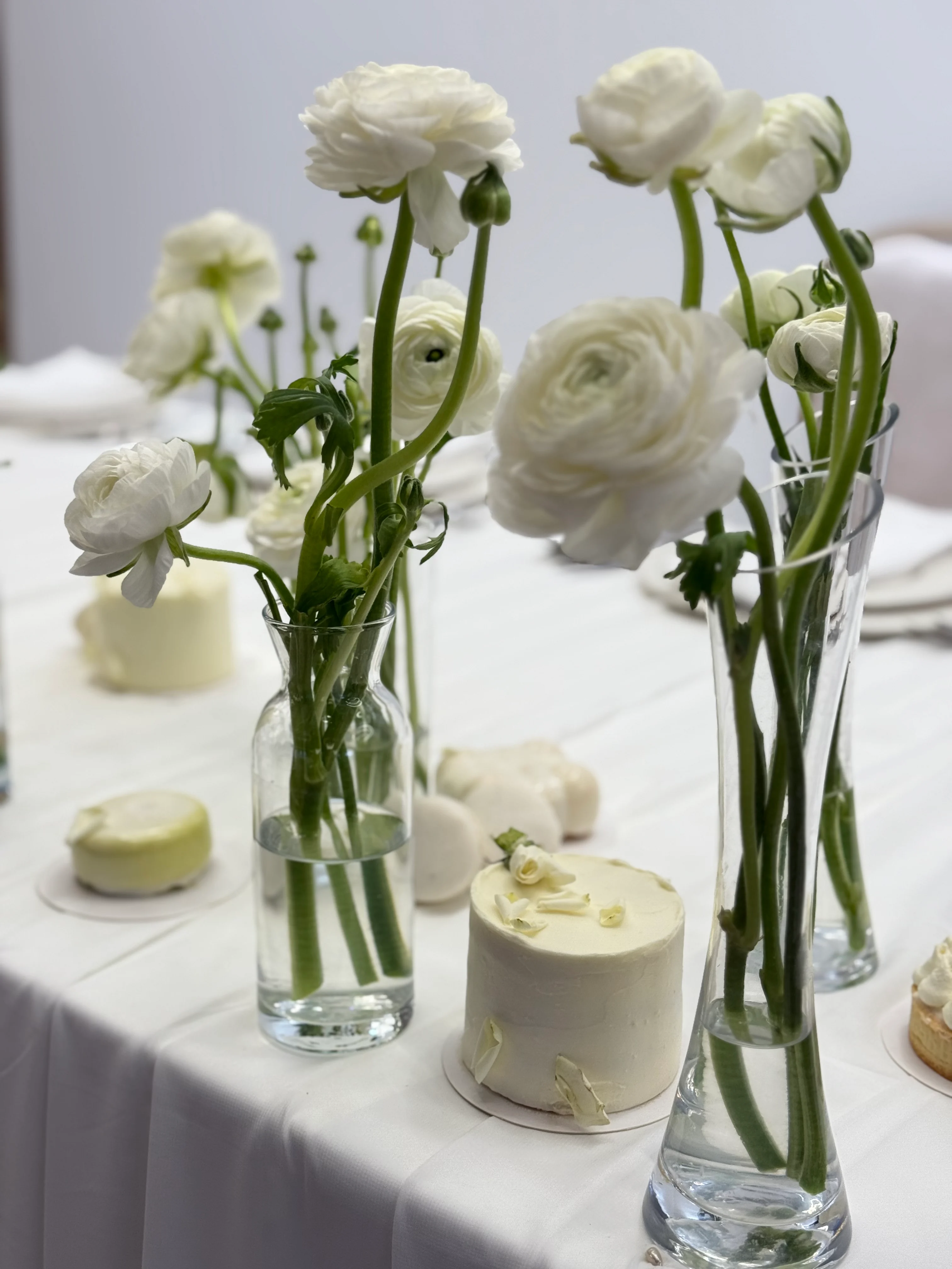 White ranunculus in glass vases on dining table